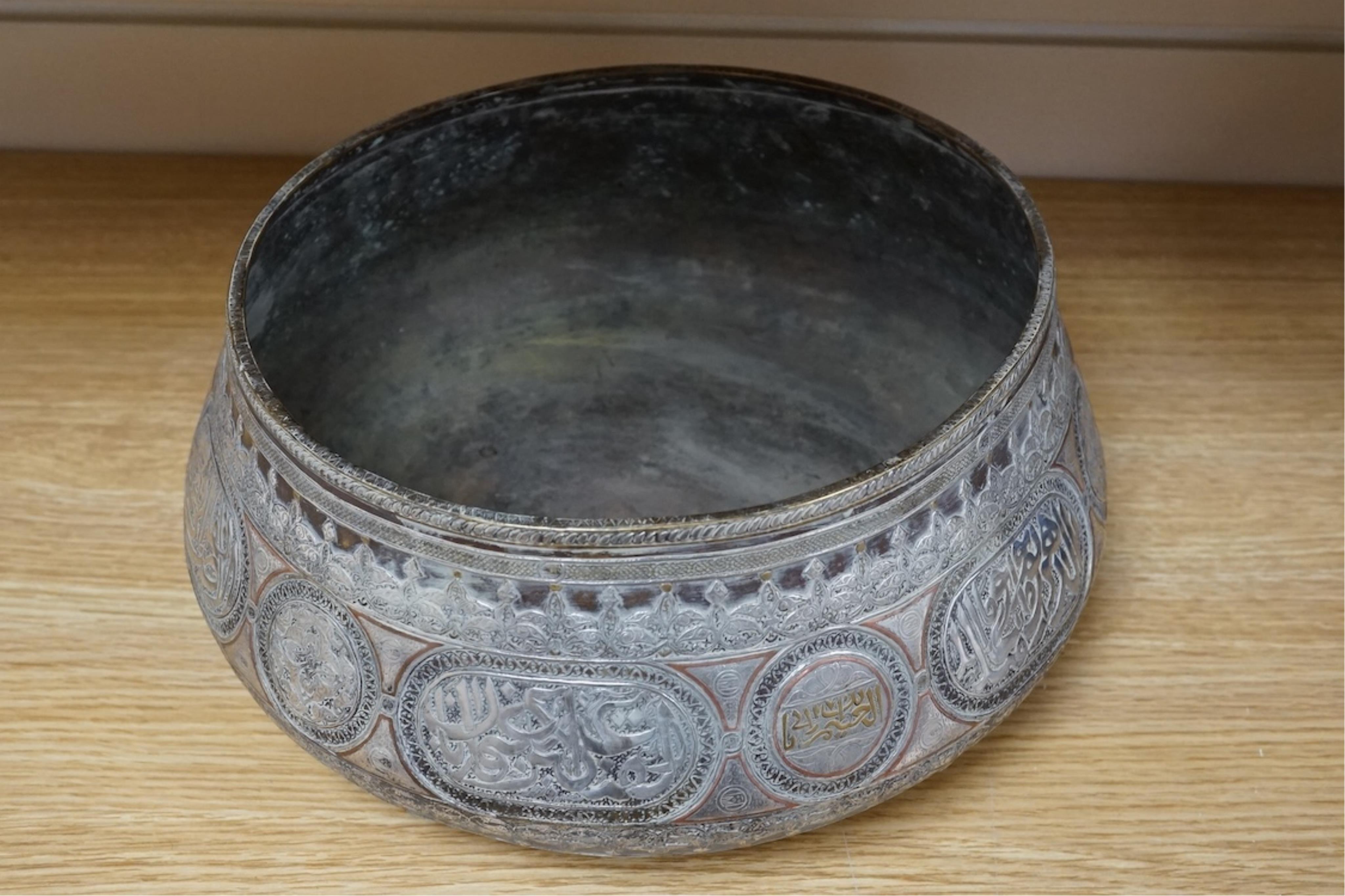 A late 19th century Mamluk style brass basin inlaid with silver and copper decoration, 29cm diameter